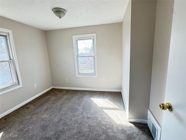2106 17th St SW, Akron, OH 44314 - unfurnished room with baseboards, visible vents, dark carpet, and a textured ceiling