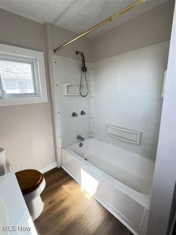 2106 17th St SW, Akron, OH 44314 - bathroom featuring toilet, shower / bath combination, a textured ceiling, and wood finished floors