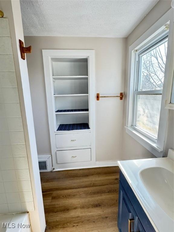 2106 17th St SW, Akron, OH 44314 - bathroom featuring visible vents, a textured ceiling, wood finished floors, and vanity