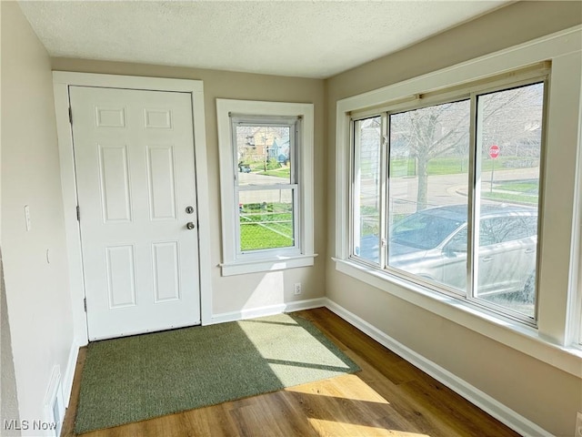 2106 17th St SW, Akron, OH 44314 - entryway with dark wood finished floors, baseboards, and a textured ceiling