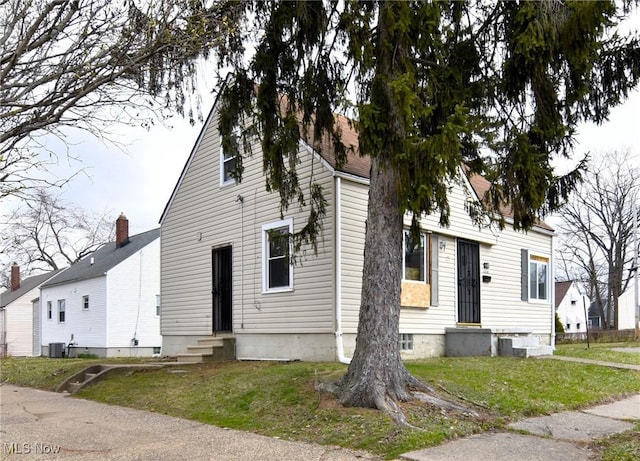 1118 Hartford Ave, Akron, OH 44320 - view of front facade featuring a front yard, cooling unit, and entry steps