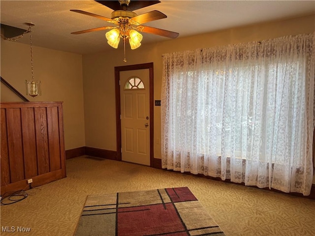 entrance foyer with baseboards and ceiling fan