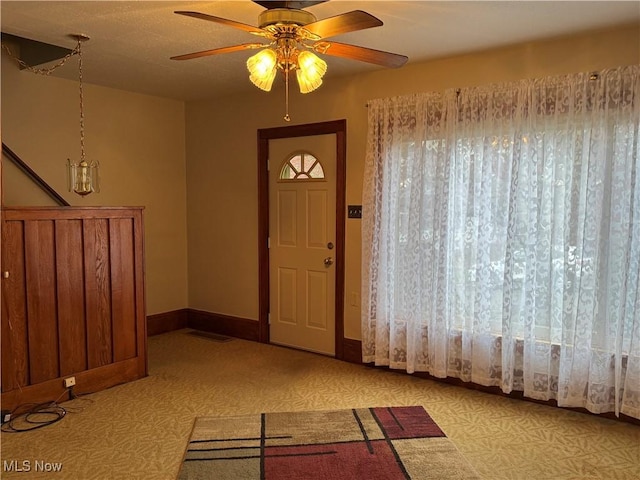 foyer entrance featuring baseboards and ceiling fan