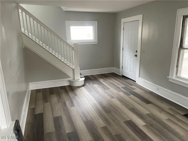 foyer featuring baseboards, stairway, and wood finished floors