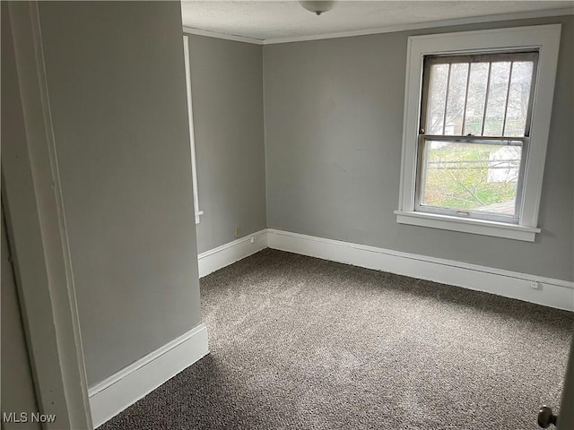 unfurnished room with dark carpet, crown molding, and baseboards