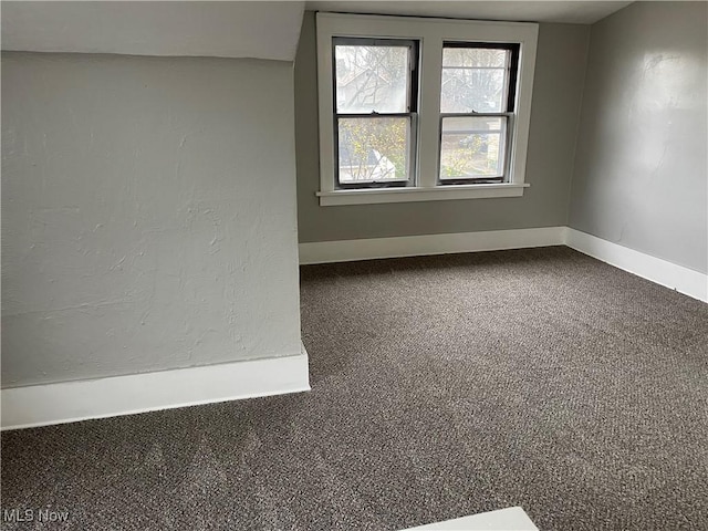 spare room with baseboards and carpet