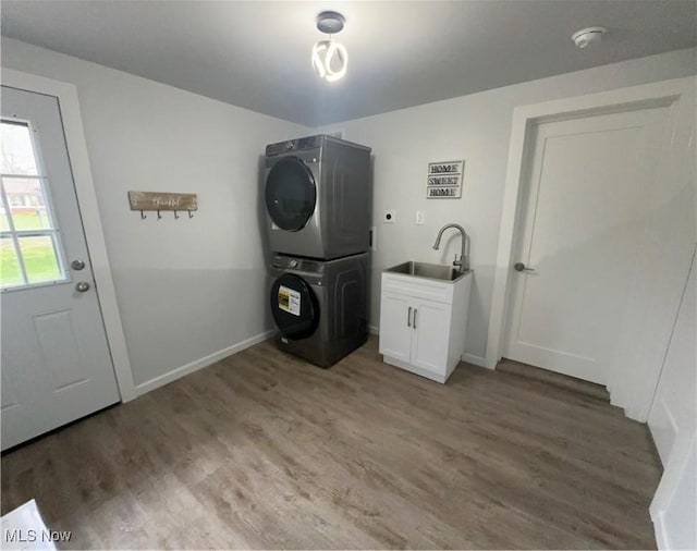 9171 Ridge Rd, North Royalton, OH 44133 - laundry area featuring estacked washer and dryer, light wood-style flooring, and cabinet space