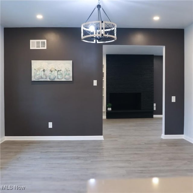 9171 Ridge Rd, North Royalton, OH 44133 - unfurnished dining area featuring wood finished floors, a chandelier, recessed lighting, and a fireplace