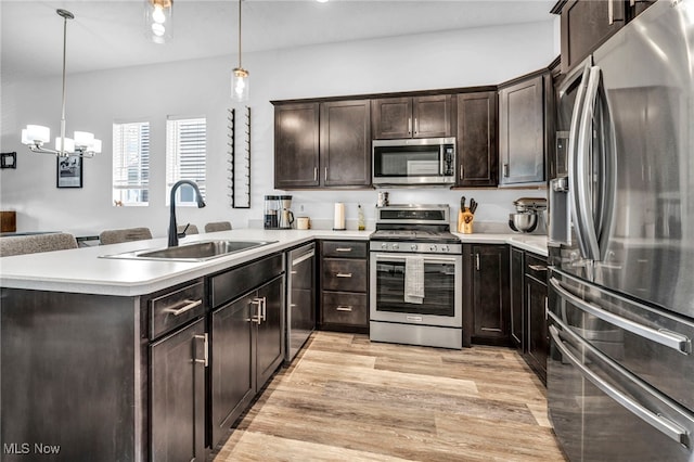 7510 Elton Ave, Cleveland, OH 44102 - kitchen with light countertops, stainless steel appliances, a sink, light wood-style floors, and a peninsula