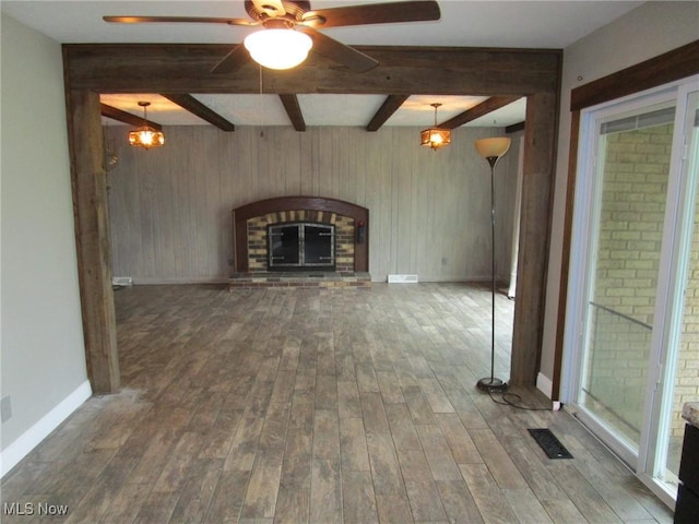 3701 Villa Marie Rd, Lowellville, OH 44436 - unfurnished living room with visible vents, beamed ceiling, a brick fireplace, wood finished floors, and a ceiling fan