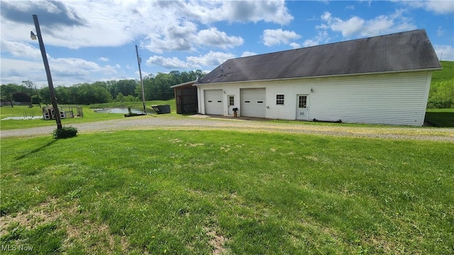 53525 Somerton Hwy, Jerusalem, OH 43747 - view of side of home featuring a garage, a lawn, dirt driveway, and a water view