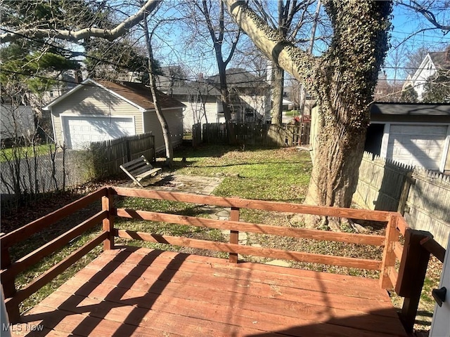 deck featuring driveway, an outbuilding, fence, and a detached garage