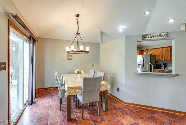 dining room with tile patterned floors, baseboards, and a chandelier