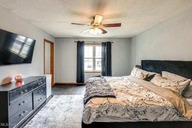 bedroom with a ceiling fan, a textured ceiling, baseboards, and wood finished floors