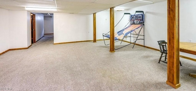 finished below grade area with a drop ceiling, carpet, and baseboards