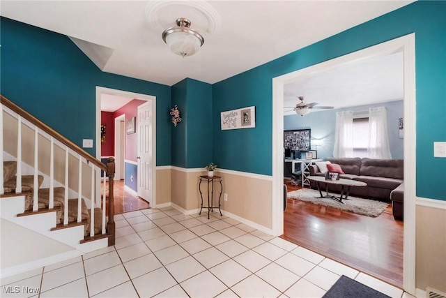 tiled entrance foyer featuring visible vents, baseboards, ceiling fan, and stairway