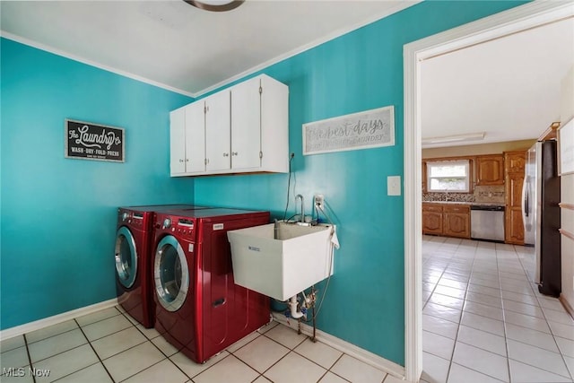 clothes washing area featuring a sink, separate washer and dryer, baseboards, and light tile patterned floors