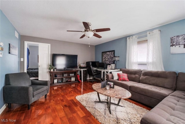 living room featuring ceiling fan, visible vents, and dark wood-type flooring
