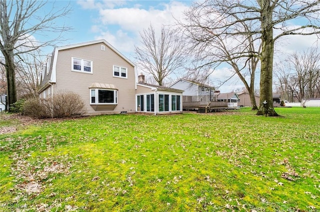 rear view of house featuring a sunroom, a gambrel roof, and a lawn