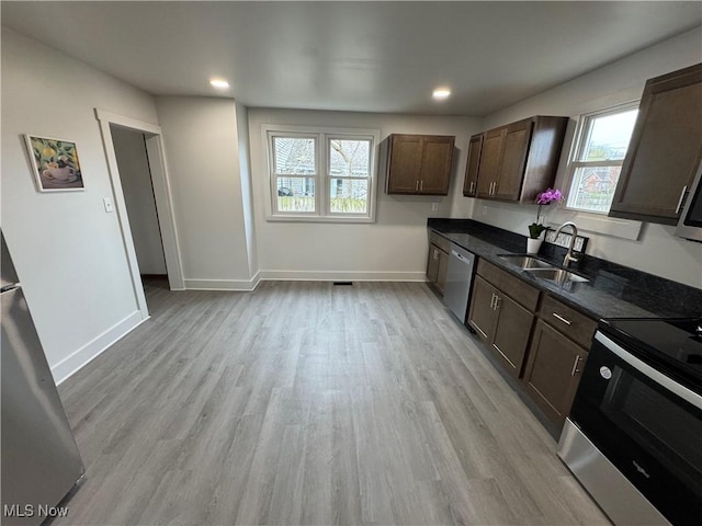 kitchen with a sink, stainless steel appliances, plenty of natural light, light wood-style flooring, and recessed lighting