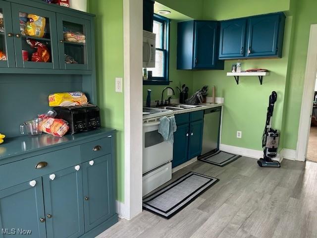 kitchen featuring dishwasher, electric range oven, a sink, and light wood-style floors