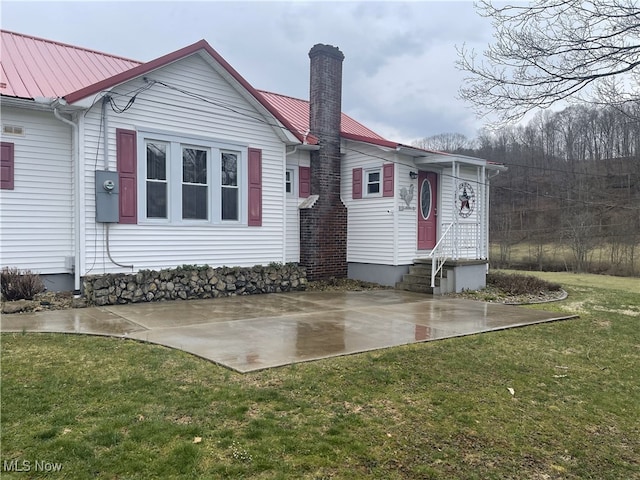 23314 Frostyville Rd, Caldwell, OH 43724 - exterior space with a lawn, a chimney, metal roof, and entry steps