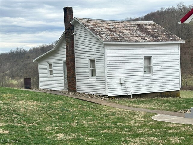 23314 Frostyville Rd, Caldwell, OH 43724 - view of side of home with a chimney and a yard