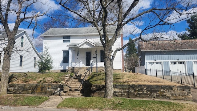 228 N 8th St, Coshocton, OH 43812 - view of front facade with fence, stairway, a porch, and a garage