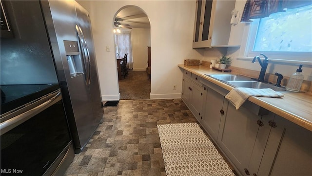 228 N 8th St, Coshocton, OH 43812 - kitchen with light countertops, stainless steel electric range oven, a sink, arched walkways, and ceiling fan