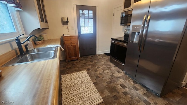 228 N 8th St, Coshocton, OH 43812 - kitchen with stone finish floor, light countertops, a sink, and stainless steel appliances