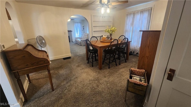 228 N 8th St, Coshocton, OH 43812 - dining space with visible vents, carpet, baseboards, a ceiling fan, and arched walkways