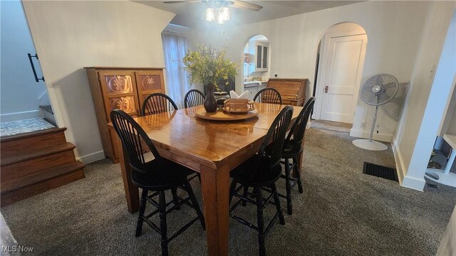 228 N 8th St, Coshocton, OH 43812 - carpeted dining room featuring stairs, baseboards, arched walkways, visible vents, and a ceiling fan