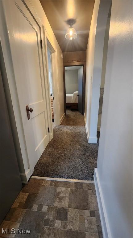 228 N 8th St, Coshocton, OH 43812 - corridor with baseboards, dark carpet, and stone finish flooring