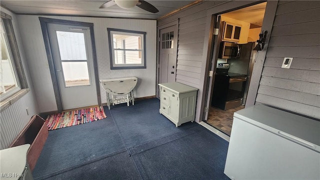 228 N 8th St, Coshocton, OH 43812 - doorway to outside with ceiling fan and wood walls