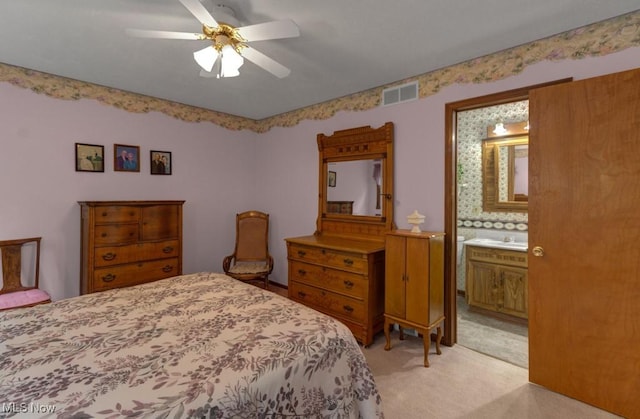 bedroom with light carpet, ensuite bath, ceiling fan, and visible vents