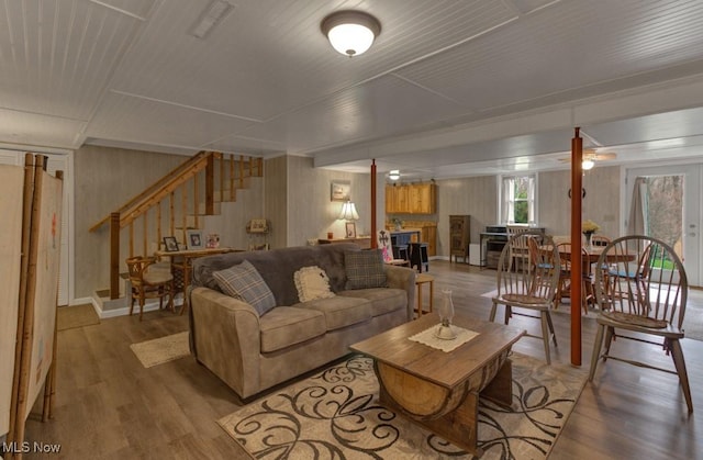 living room with stairway, baseboards, visible vents, a ceiling fan, and wood finished floors