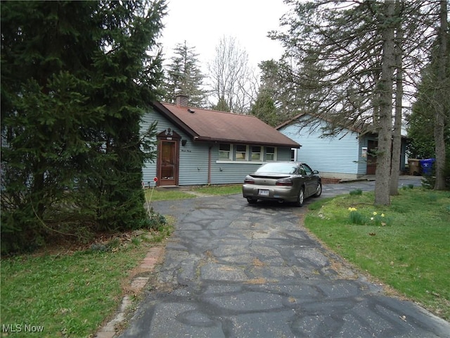 view of front of home with aphalt driveway and a chimney