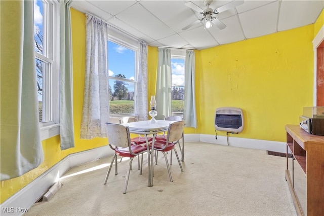 dining area with carpet, baseboards, a ceiling fan, heating unit, and a paneled ceiling
