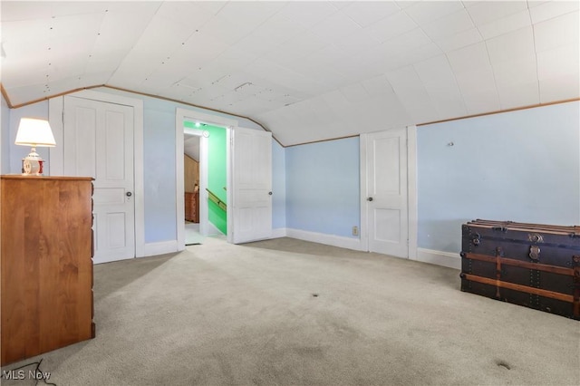 additional living space with baseboards, lofted ceiling, and carpet floors