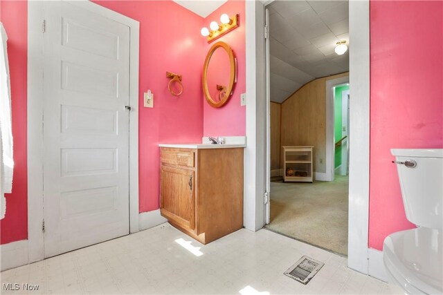 bathroom featuring tile patterned floors, visible vents, vanity, and vaulted ceiling