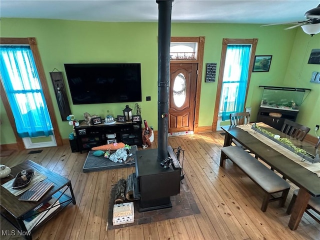 35955-35959 Bower Rd, Scio, OH 43988 - living room with wood-type flooring, ceiling fan, a wood stove, and plenty of natural light