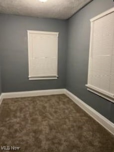 carpeted spare room with baseboards