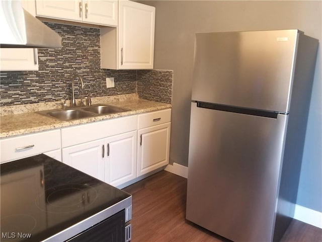 kitchen with white cabinetry, electric range, freestanding refrigerator, backsplash, and a sink