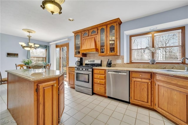 6722 Silvermound Dr, Mentor, OH 44060 - kitchen with stainless steel appliances, a sink, a chandelier, custom range hood, and brown cabinetry
