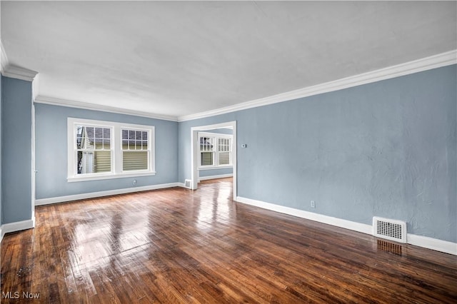 unfurnished room with baseboards, visible vents, crown molding, and wood-type flooring