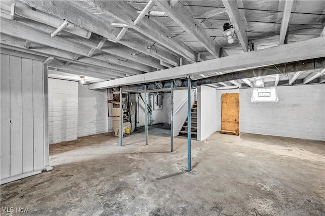 basement with heating unit, stairs, and electric panel