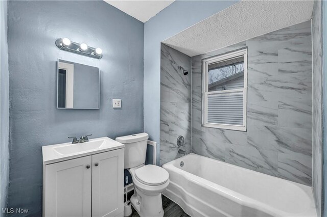 bathroom featuring toilet, vanity, and bathing tub / shower combination