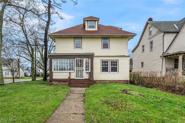 american foursquare style home featuring a front lawn and entry steps