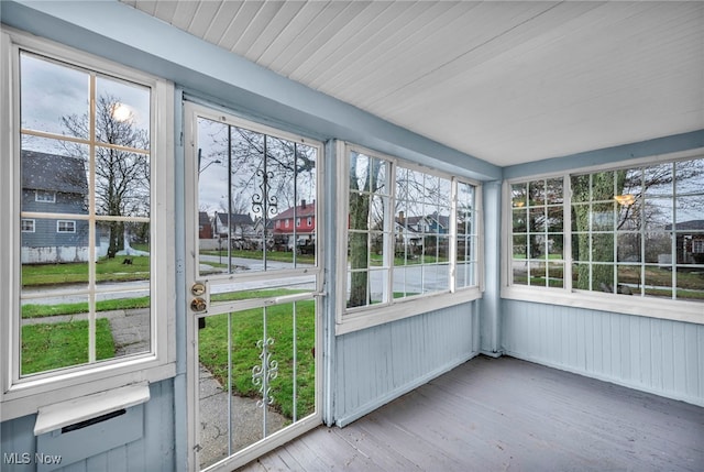 unfurnished sunroom with a healthy amount of sunlight and wood finished floors