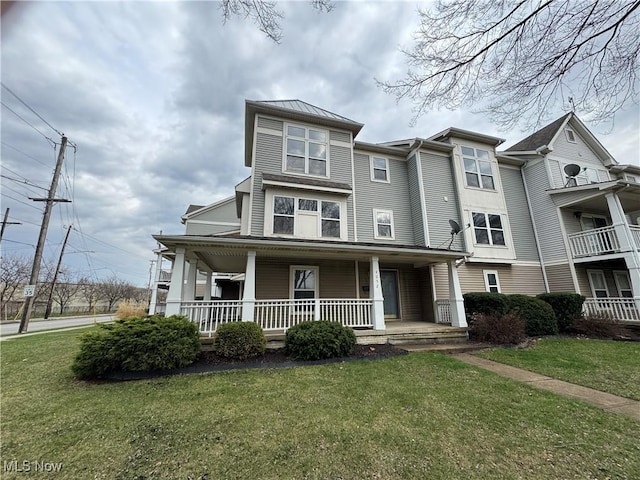 townhome / multi-family property featuring a front lawn and covered porch